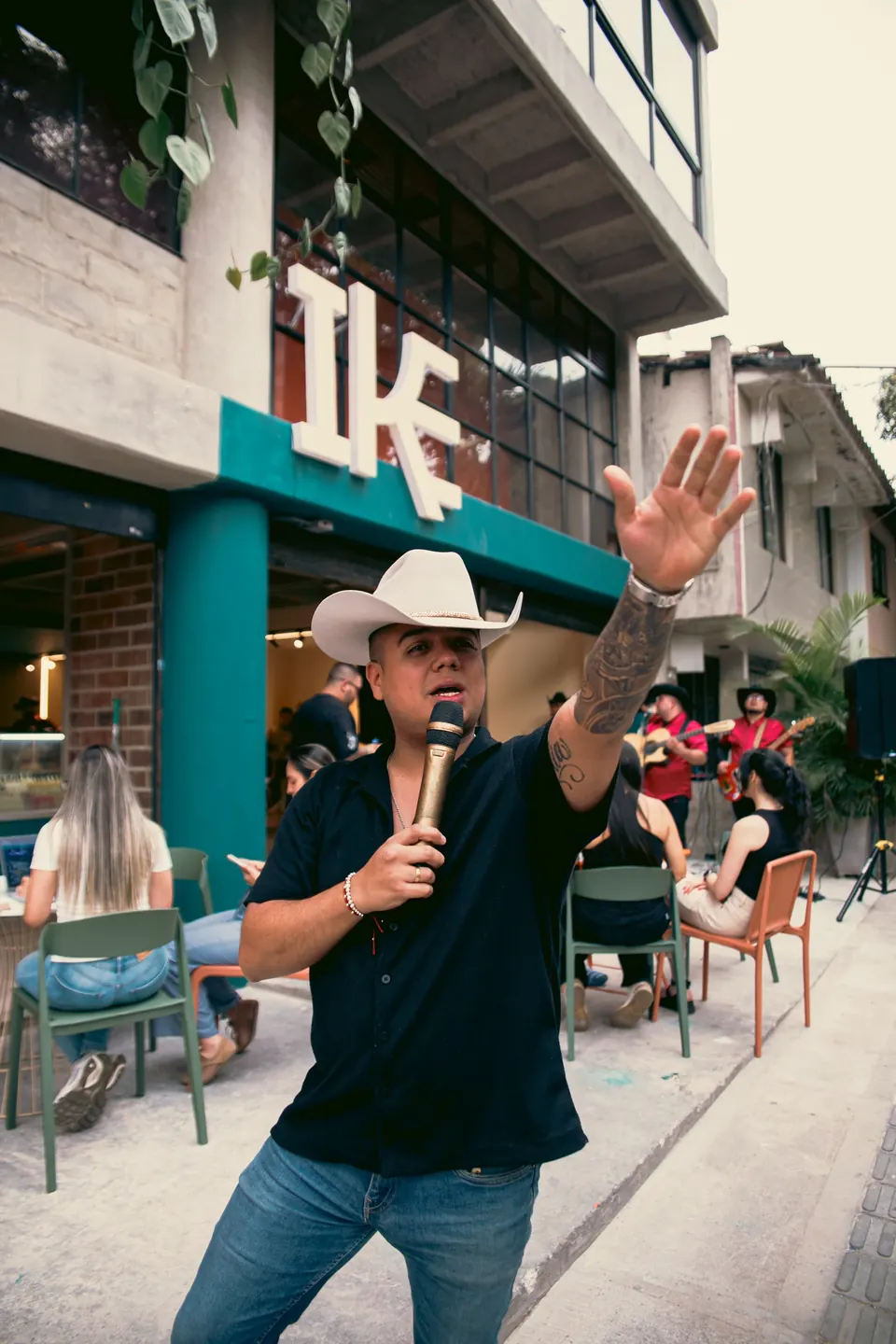 Evento en vivo con cantante y público frente al local de IKE en Medellín
